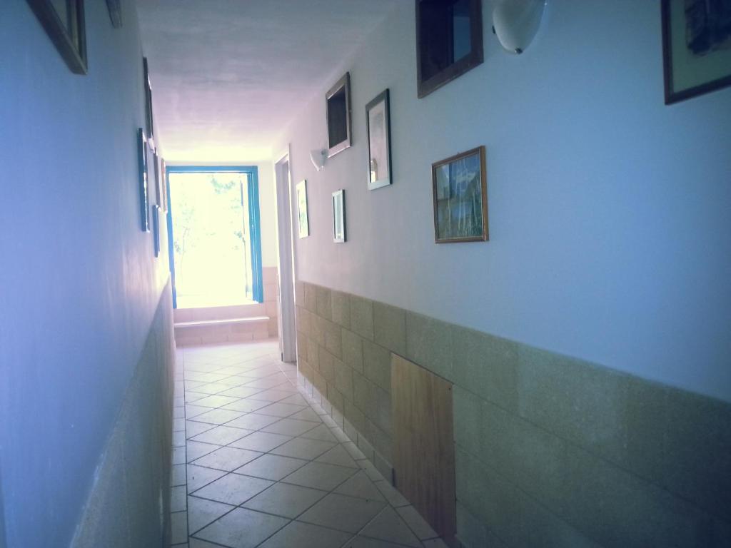 a hallway with a wall with pictures on it at Appartamenti Frassanito in Conca Specchiulla