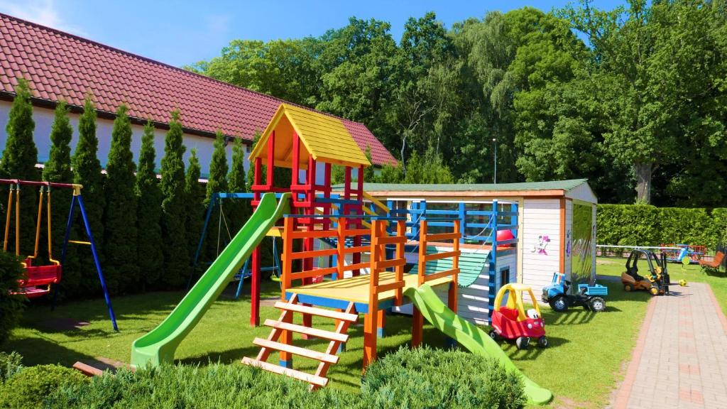a playground with colorful play equipment in a yard at Aida Domki Letniskowe in Rewal