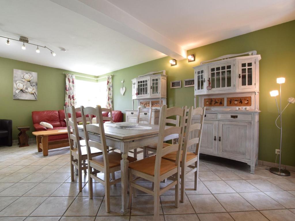 een eetkamer met een tafel en stoelen bij An old farmhouse in a peaceful Ardennes village in Jehonville