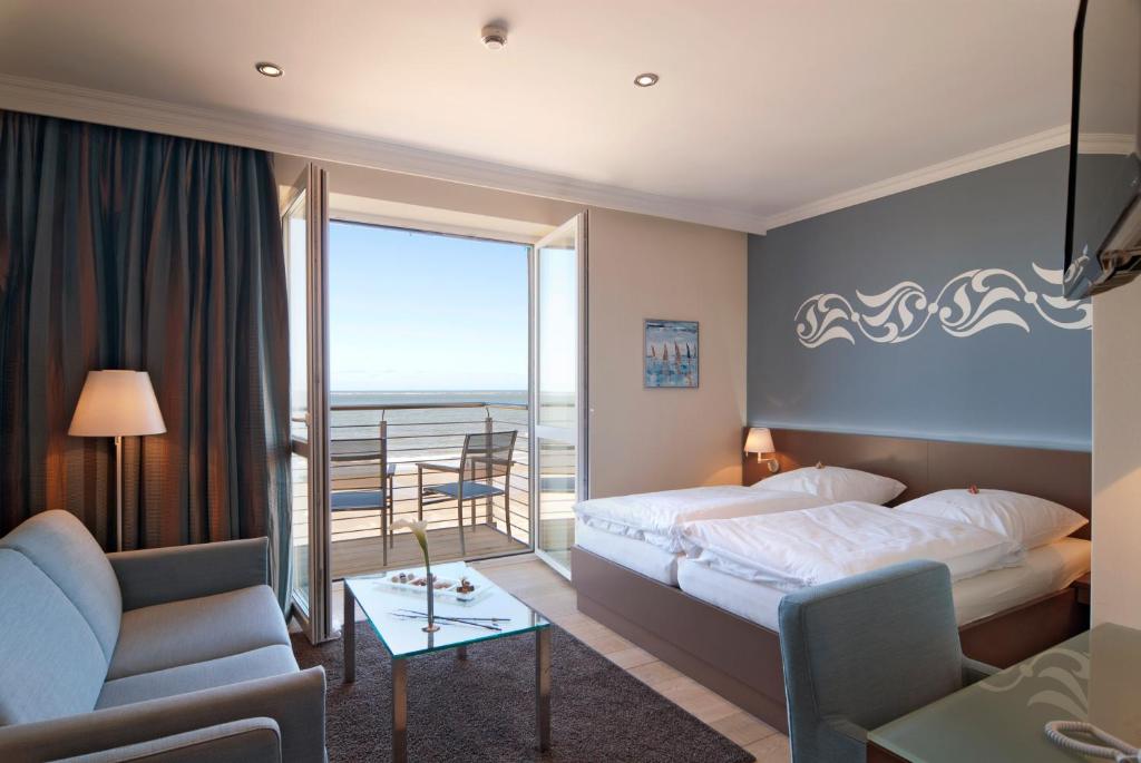 ein Hotelzimmer mit einem Bett und einem Balkon in der Unterkunft Strandhotel Georgshöhe in Norderney