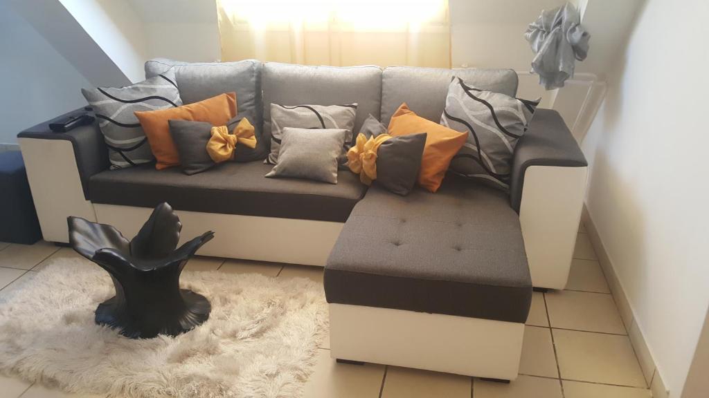 ein Sofa mit vielen Kissen darauf im Wohnzimmer in der Unterkunft Főnix de Lux Apartman in Debrecen