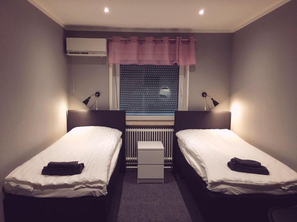 2 camas en una habitación pequeña con ventana en Motell Trafikanten en Bygdeå