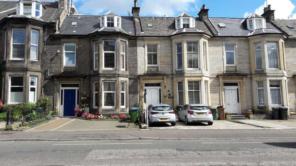 a large house with two cars parked in front of it at Capital House in Edinburgh