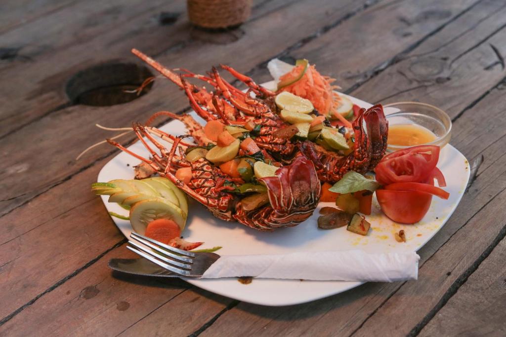 a plate of food with a lobster on a table at Demani Lodge Zanzibar in Paje