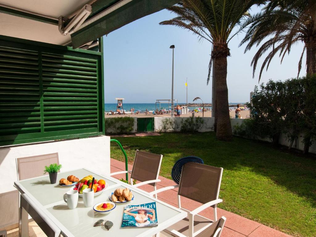 a table with fruit on it with a view of the beach at Apartment Las Burras in San Agustin