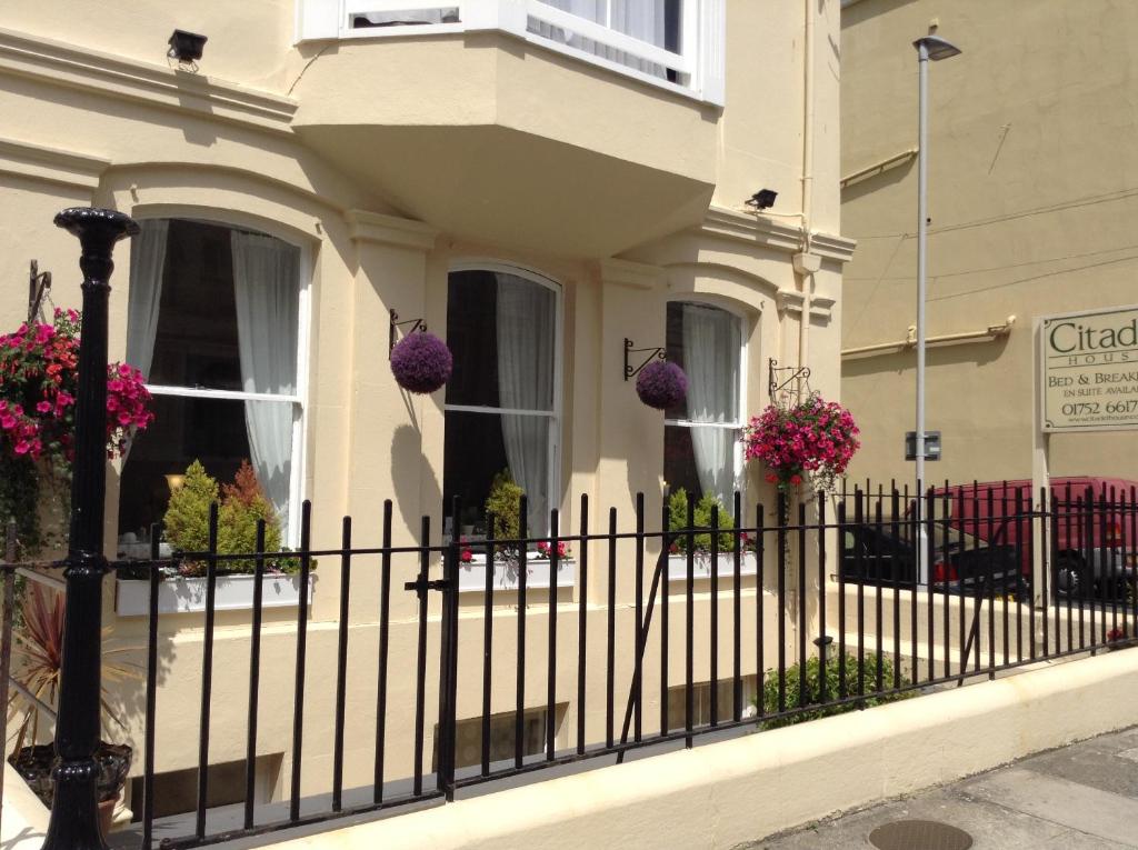 a black fence in front of a house with flowers at Citadel House Hotel in Plymouth