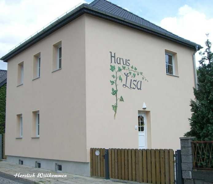 Ferienwohnungen _ Haus Lisa_ في سنفتنبرغ: مبنى ابيض عليه لافته جانبيه