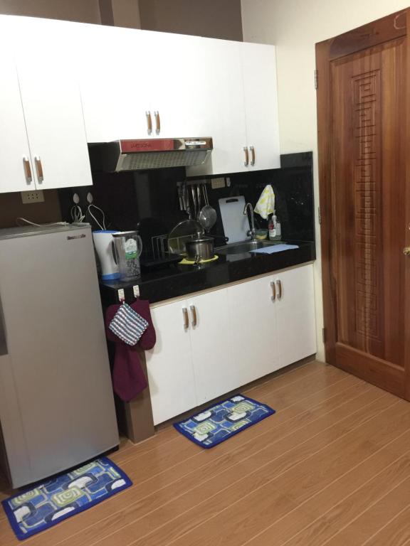 eine Küche mit weißen Schränken und einem Kühlschrank in der Unterkunft SD4 Studio Apartment in Loculan