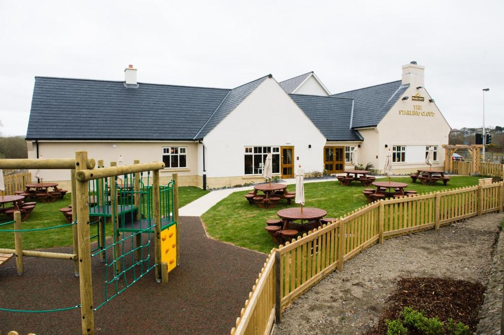 a playground in front of a building with tables at Starling Cloud in Aberystwyth