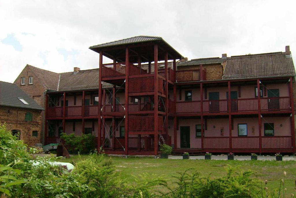 ein großes rotes Gebäude mit einem großen Balkon in der Unterkunft Herberge Zum Steiger Franz in Sedlitz