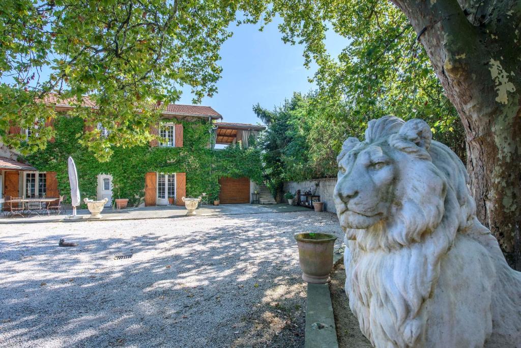 a statue of a lion in front of a tree at Gîte Le Planier in Saint-Priest