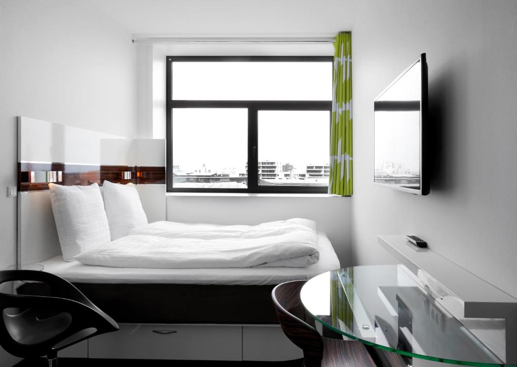 a bedroom with a bed with a window and a glass table at Wakeup - Aarhus in Aarhus