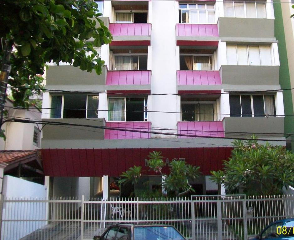 un edificio con puertas rosas y una valla delante de él en Apartamento Edificio Mirage, en Salvador