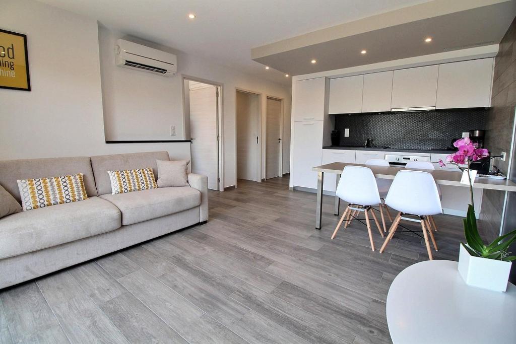 a living room with a couch and a table and chairs at Residence ACQUA LINDA Porticcio in Porticcio
