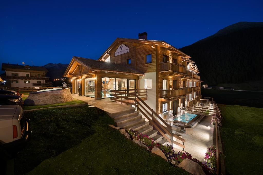 une grande maison avec une terrasse couverte et une maison dans l'établissement Hotel Sporting Family Hospitality, à Livigno