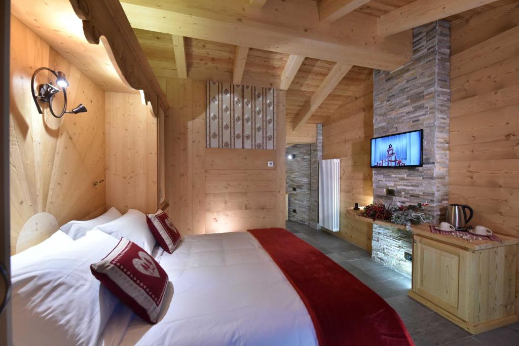 1 dormitorio con 1 cama grande en una habitación con paredes de madera en Il Cuore Del Cervino, en Breuil-Cervinia