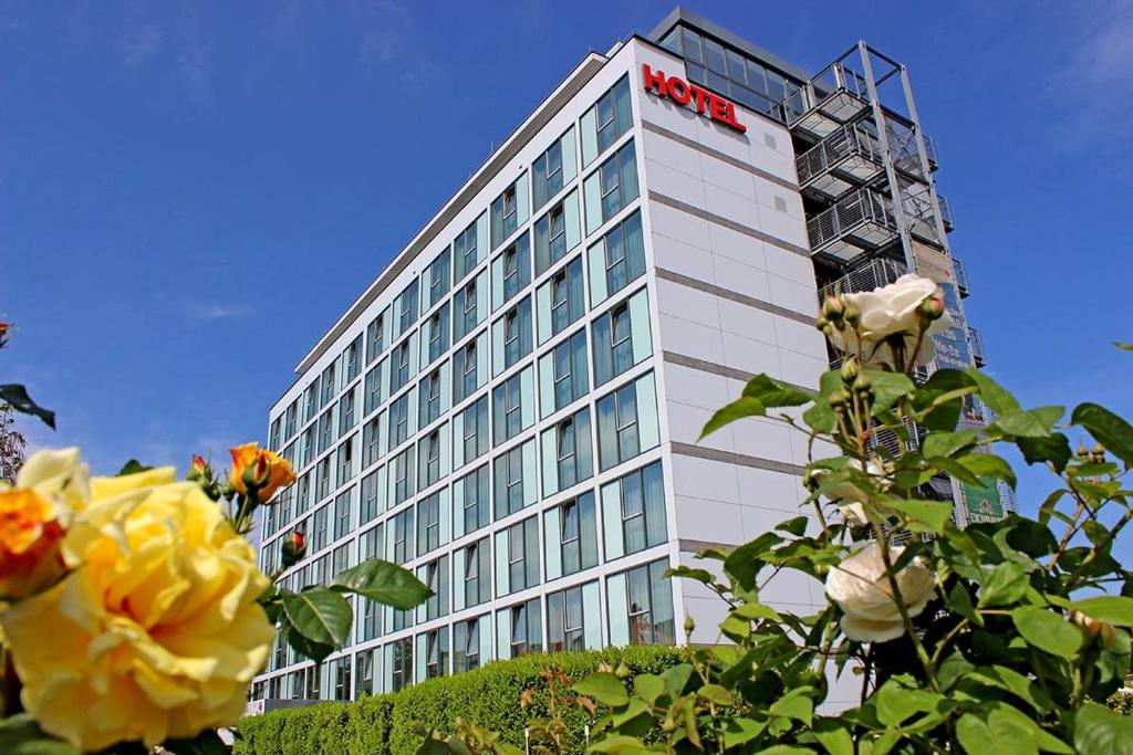 a hotel building with a sign on the side of it at Panorama Hotel am Rosengarten in Neustadt an der Weinstraße