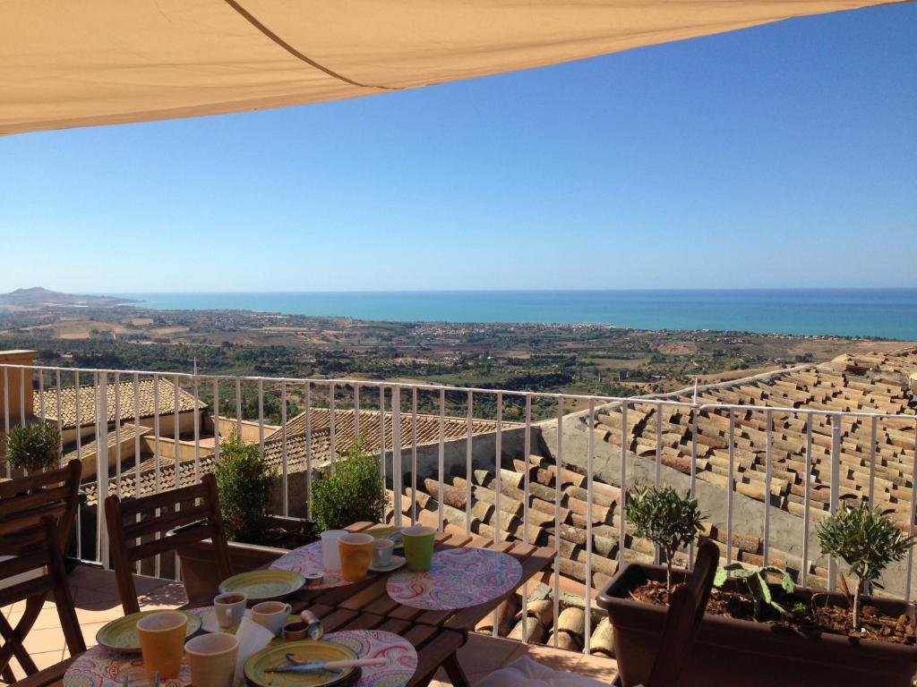 balcone con tavoli, sedie e vista sull'oceano di Le Terrazze di Pirandello a Agrigento