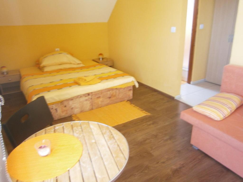 a small bedroom with a bed and a table at Penzión Ranč Šenkvice in Veľké Čaníkovce