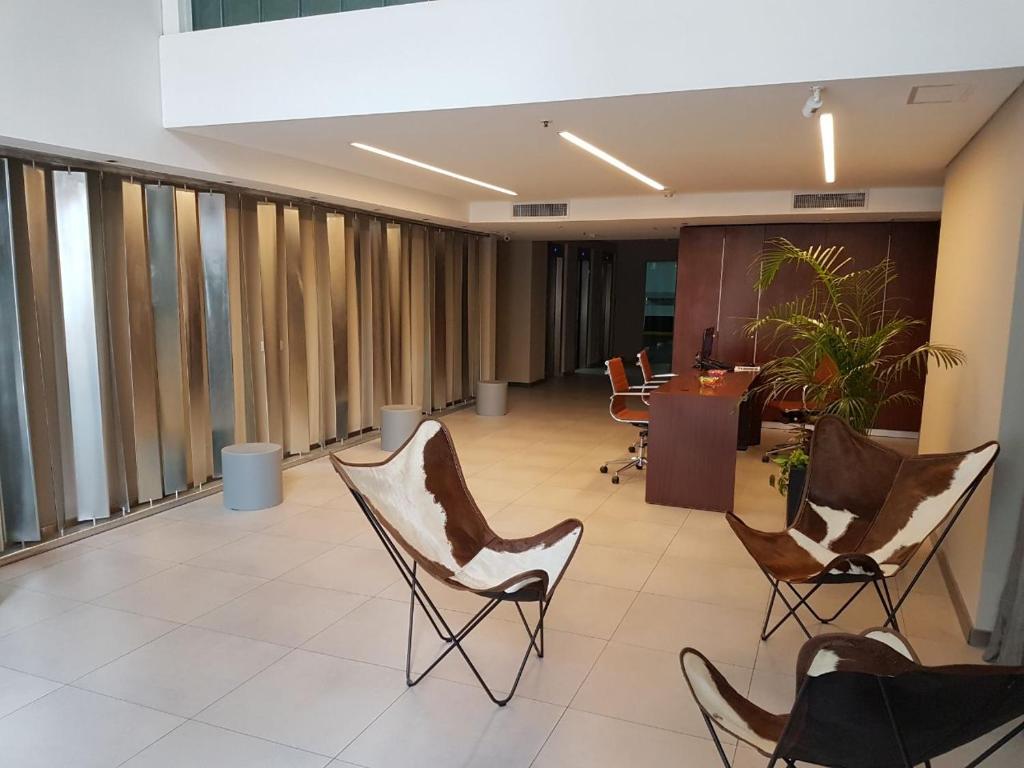 a lobby with chairs and a desk in a building at Olmos Suites in Córdoba