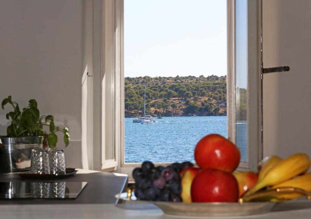 a bowl of fruit on a counter in front of a window at Swan Adriatic Apartment & Room in Šibenik