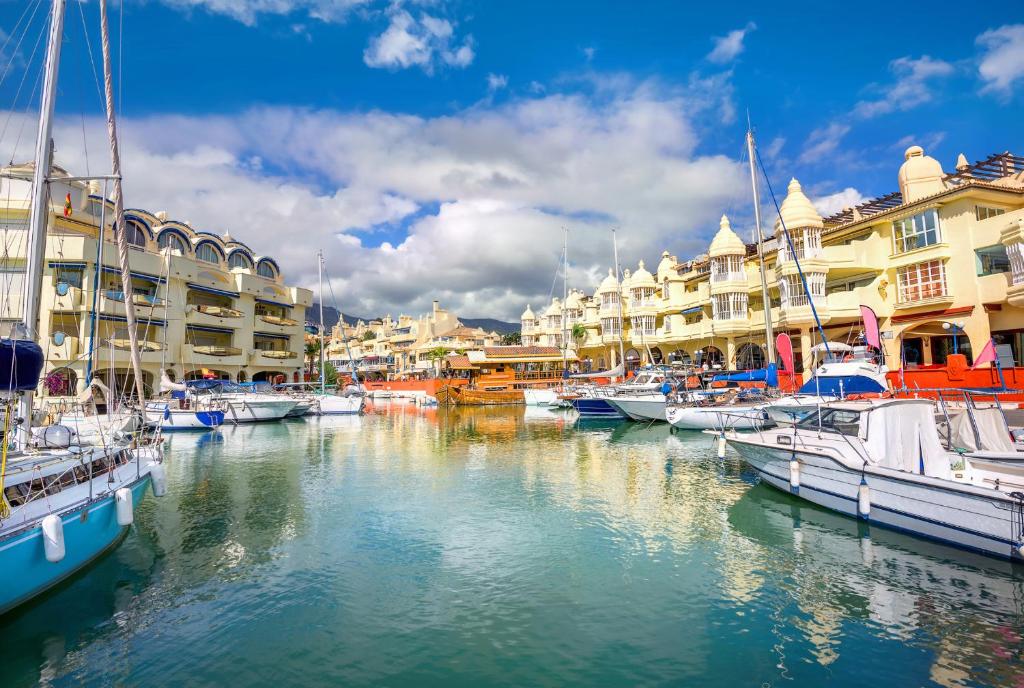 a group of boats docked in a marina with buildings at Puerto Marina waterfront apartment in Benalmádena