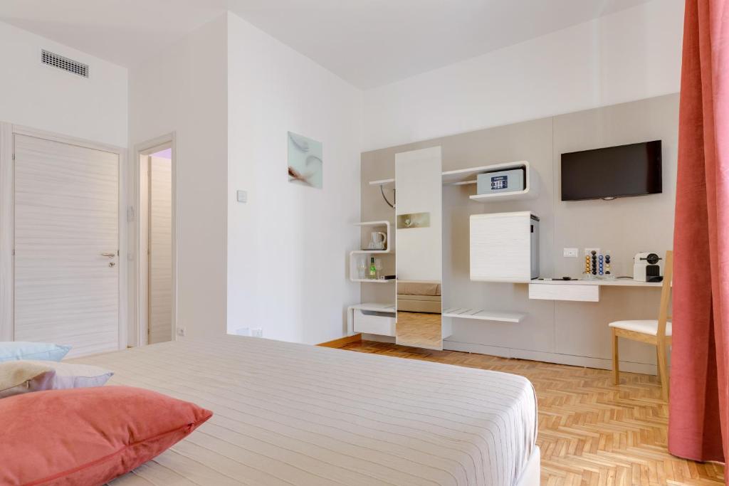 1 dormitorio blanco con 1 cama y TV en la pared en Dolce Luxury Rooms, en Roma