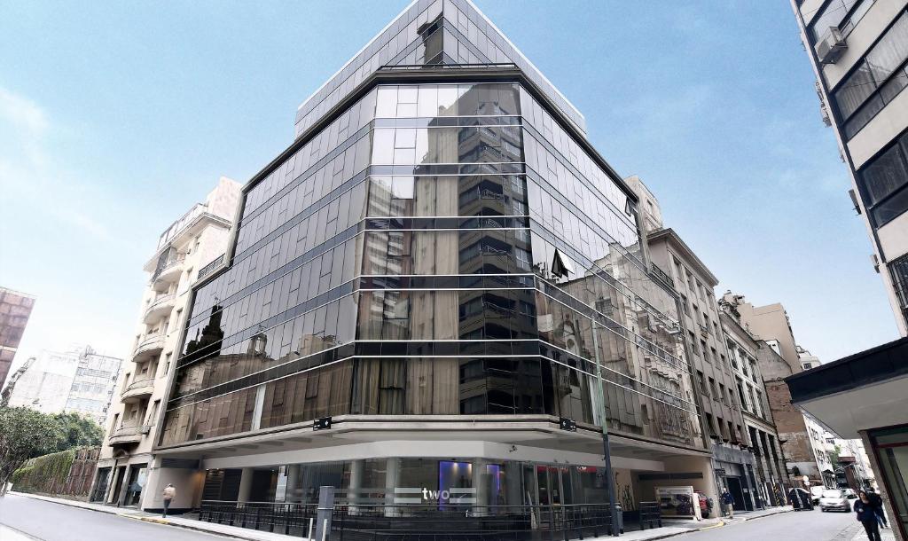 Two Hotel Buenos Aires في بوينس آيرس: مبنى زجاجي طويل على شارع المدينة