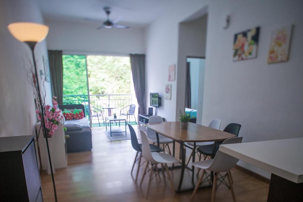een eetkamer en woonkamer met een tafel en stoelen bij Strawberry Homestay in Cameron Highlands