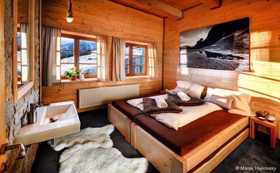 1 dormitorio con 1 cama grande y lavamanos en Horská Chata pod Soliskom, en Štrbské Pleso