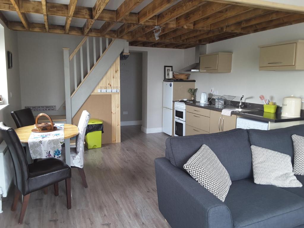 a living room with a couch and a table and a kitchen at Island View Lodge in Doolin