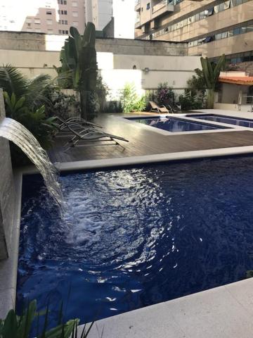 a large swimming pool with a fountain in a building at Flat Capitania Varam Ap 3053 in Guarujá