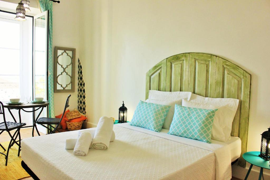 a bedroom with a large bed with blue and white pillows at Alojamentos Vista Mar-Luisa Todi in Setúbal