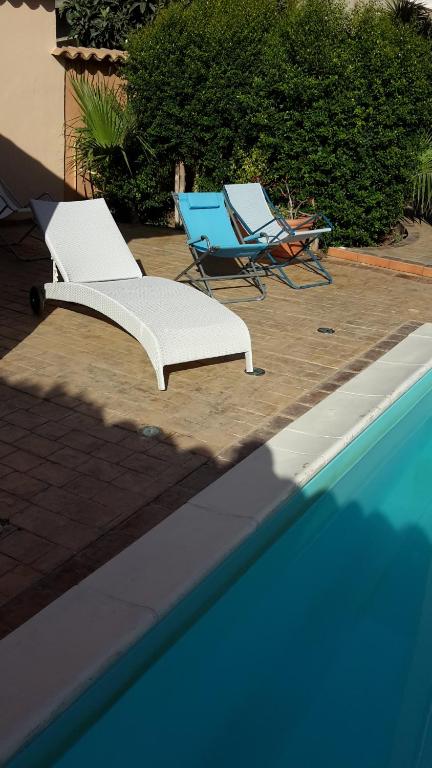 two lounge chairs and a swimming pool with two chairs and two chairssenal at Villa Salvatore in San Leone