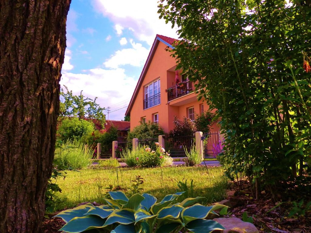 ein orangenes Haus mit einem Baum davor in der Unterkunft Ferienwohnung am Wanderweg in Aidhausen