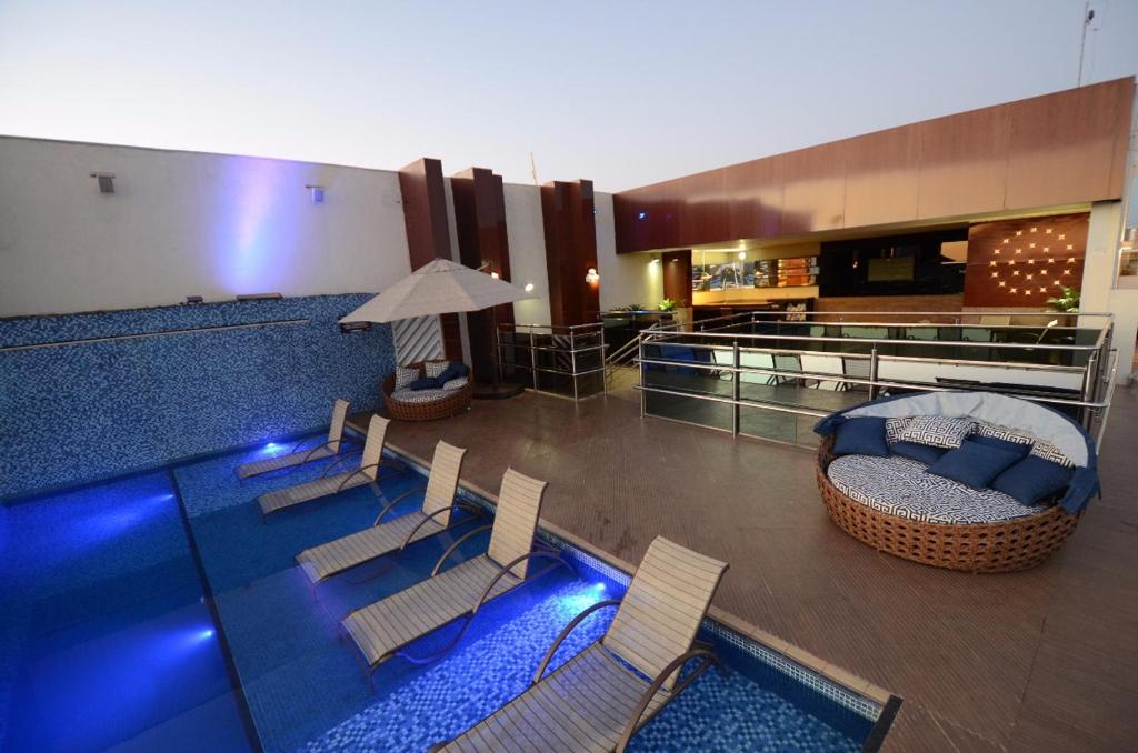 a room with a swimming pool with chairs and a couch at Oscar Hotel Executive in Porto Velho