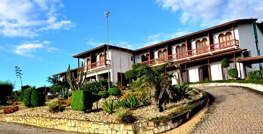uma casa grande com um jardim em frente em Hotel Serra do Ouro em Jacobina