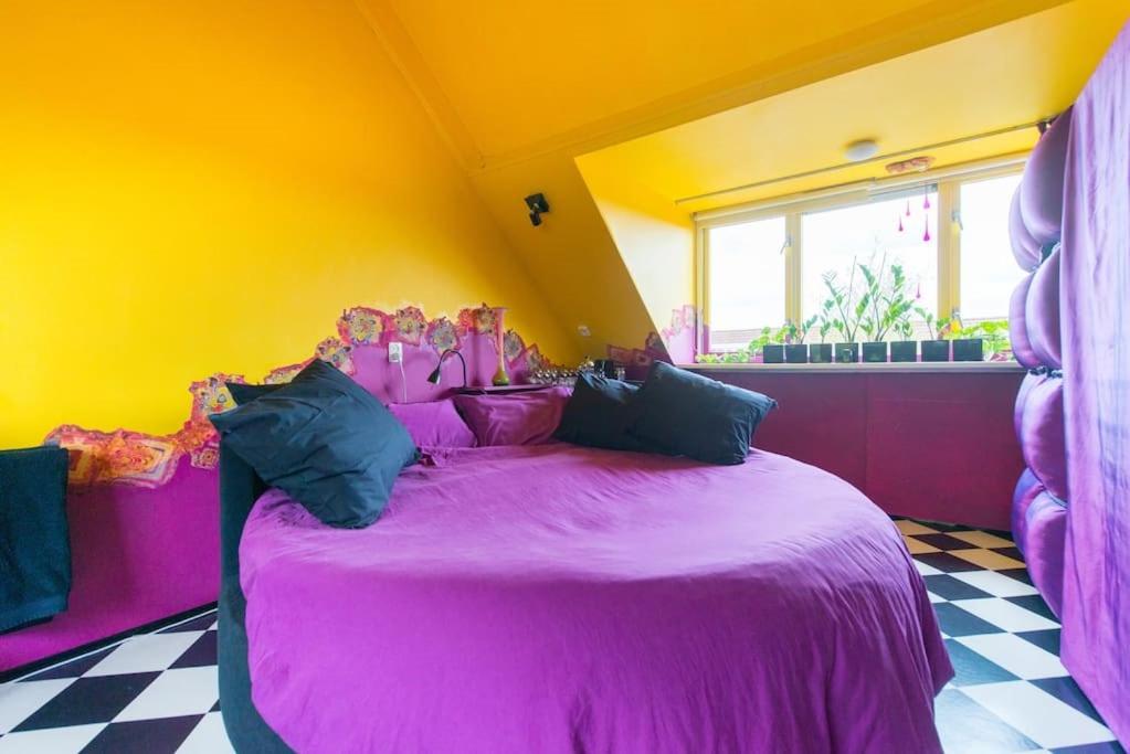 アムステルフェーンにあるArty Houseの黄色い部屋のピンクベッド付きのベッドルーム1室