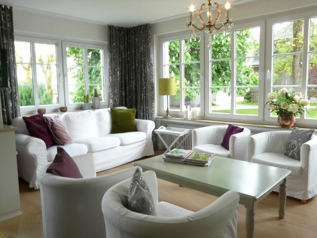a living room with white furniture and windows at Landfein Big Country House in Winterberg