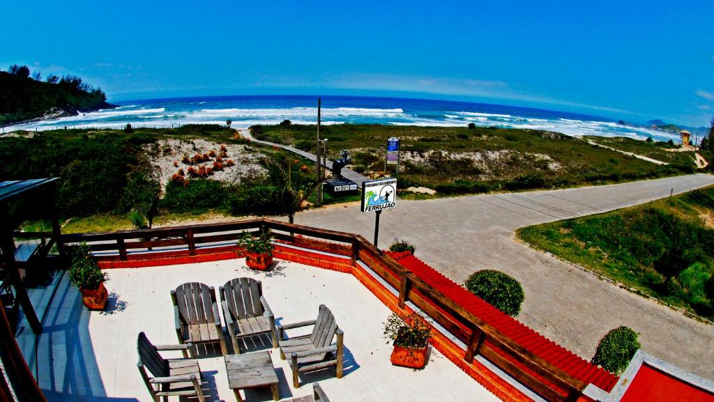 a view of a beach with chairs and the ocean at Ferrujão Pousada e Restaurante in Garopaba