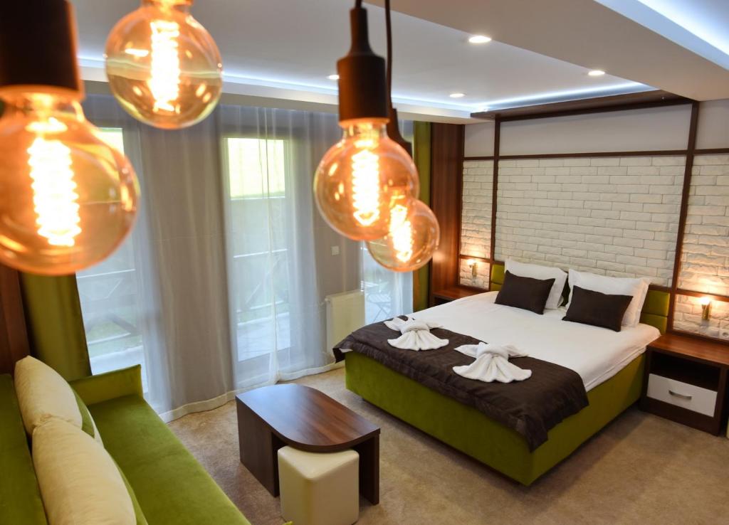 a bedroom with a bed and a couch and lights at Green Life Boutique Apartments in Bansko