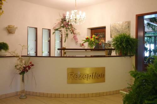 un negozio con un cartello su un muro con dei fiori di Hotel Thüringer Wald a Ilmenau