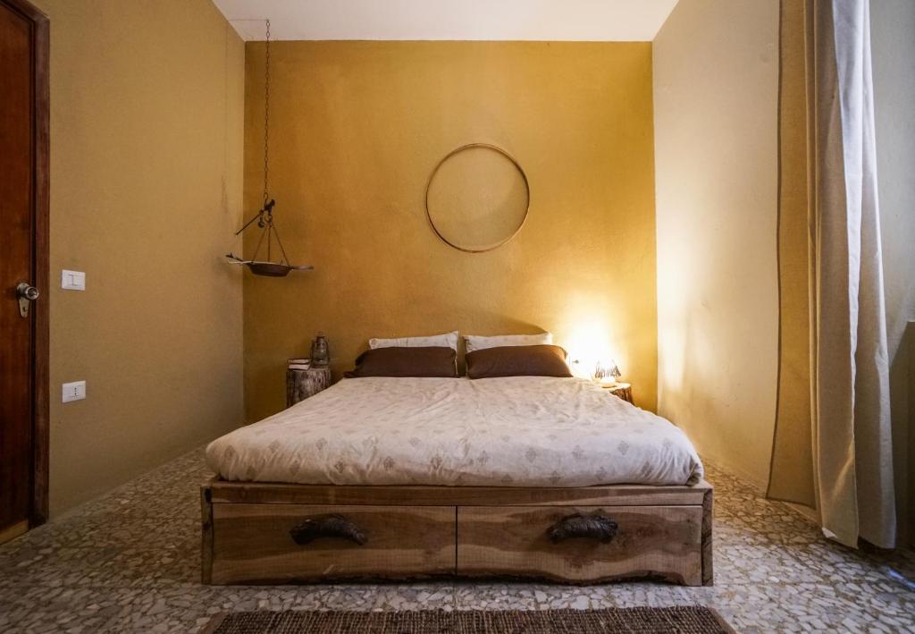 una camera da letto con un letto con uno specchio sul muro di Nannai Climbing Home a Ulassai