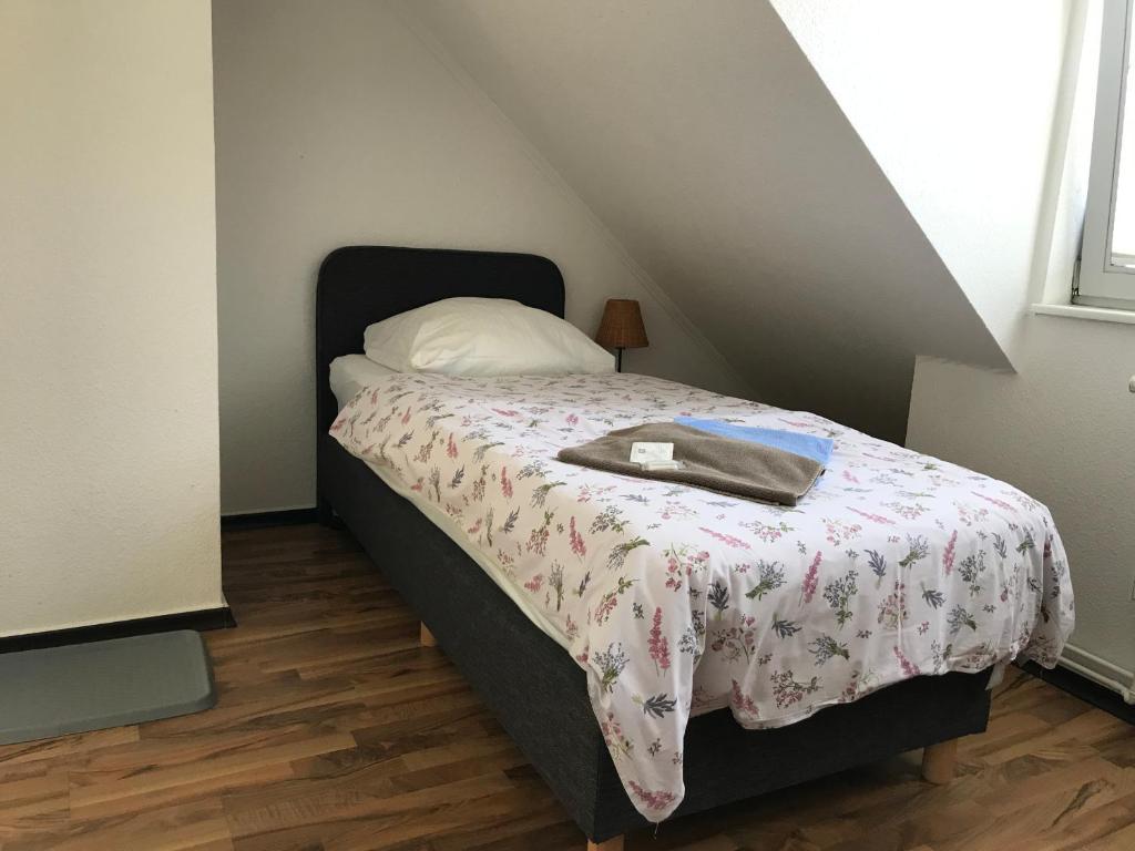 a bedroom with a bed with a blanket and a pillow at Pensione da Vito in Greifswald