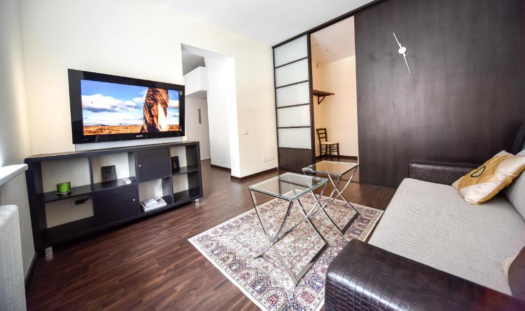 a living room with a couch and a flat screen tv at Downtown Apartment Klaipeda in Klaipėda