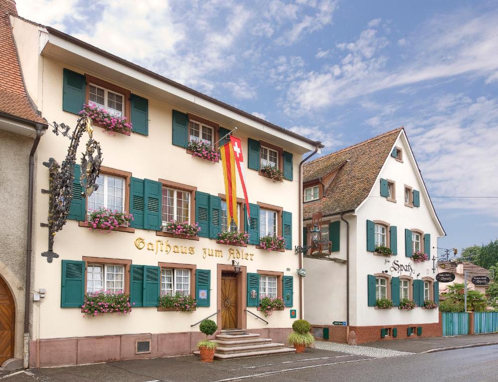 ein Gebäude mit grünen Fensterläden und Blumen darauf in der Unterkunft Hotel Adler - Weil am Rhein in Weil am Rhein