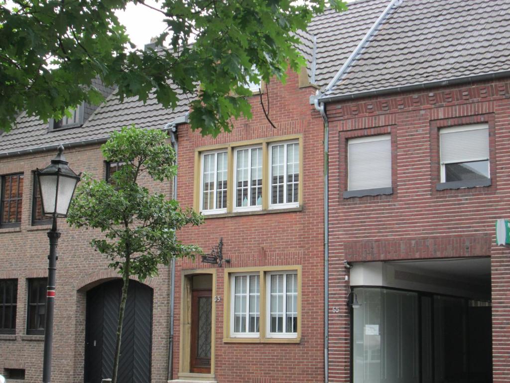 a red brick house with white windows and a street light at Pension Haus Waldfeucht in Waldfeucht
