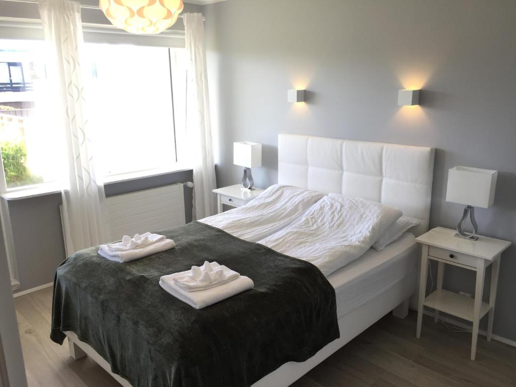 a bedroom with a bed with two white shoes on it at Ubak Guesthouse in Reykjavík