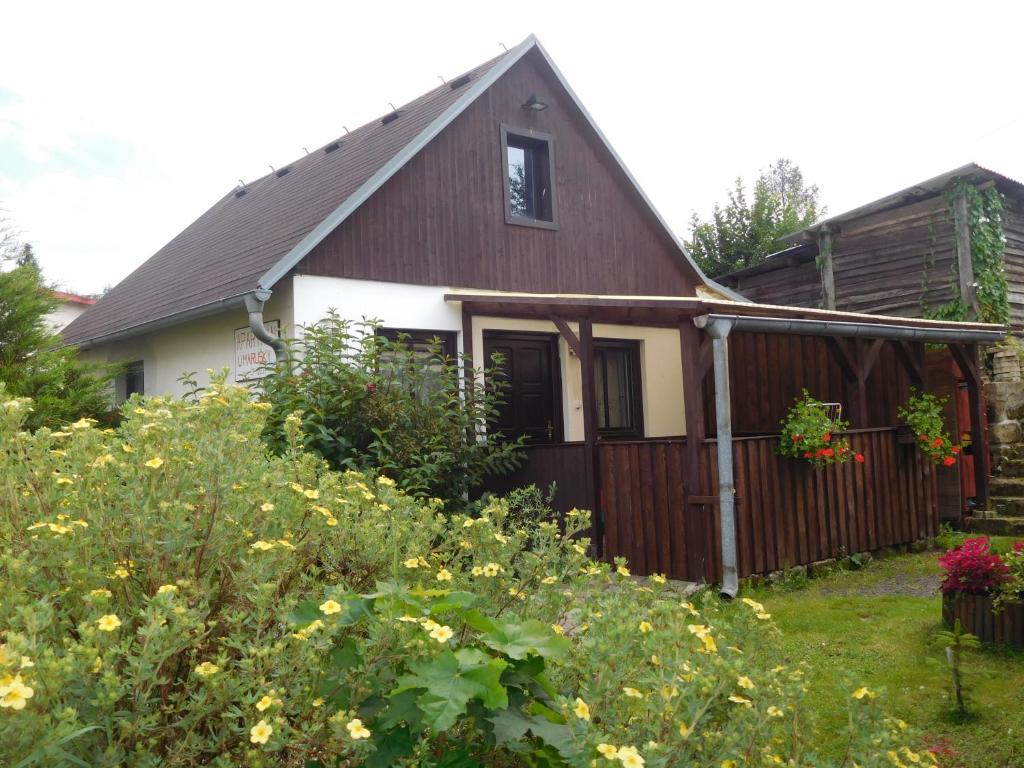 uma casa com cerca e flores no quintal em Apartmán u Marušky em Chribská