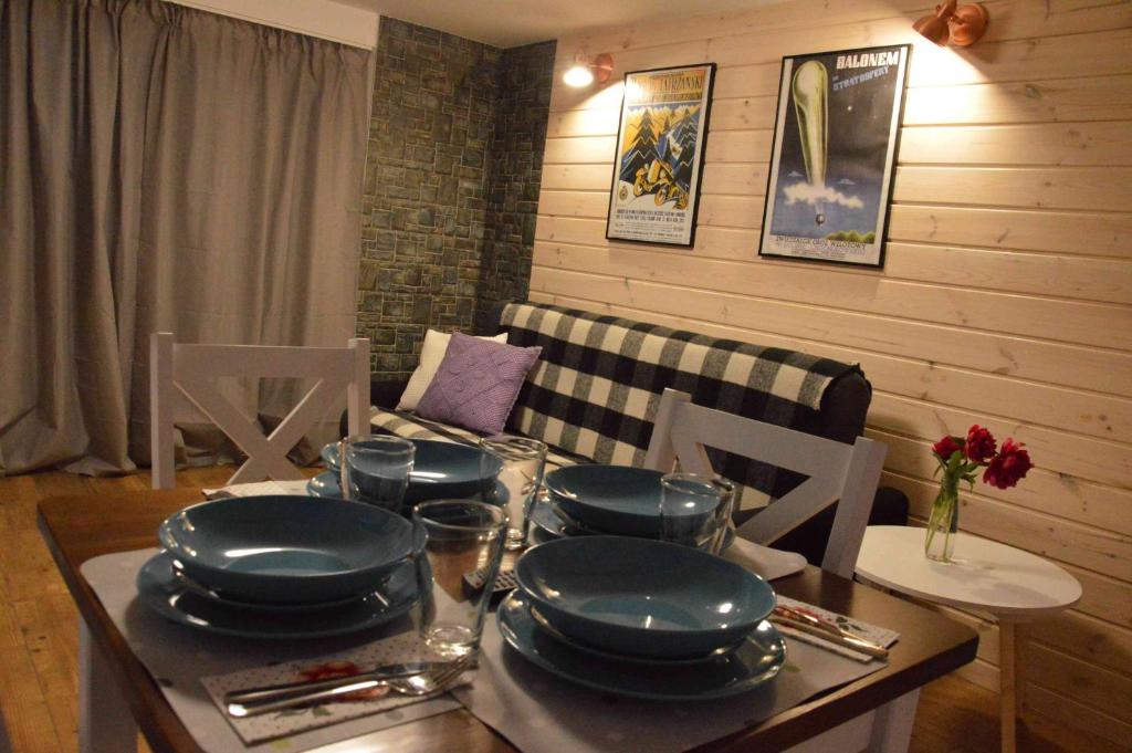a dining room with a table with plates on it at Apartamenty "Maryna House" Zakopane in Zakopane